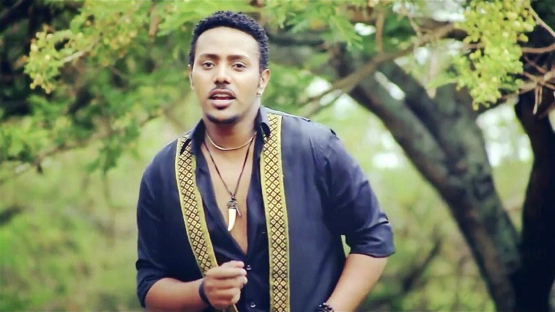 Still from the Endatay music video: Milly Wessy singing under an acacia tree